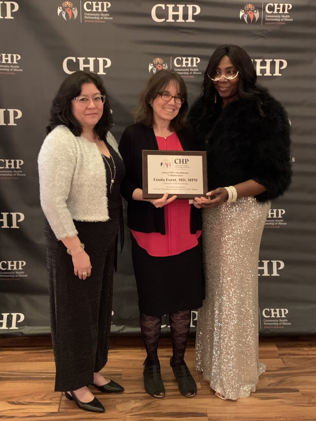 Director of the Great Lakes Center for Farmworker Health and Wellbeing receives an award from the Executive Director of Community Health Partnerships of Illinois for her longstanding work with farmworkers.